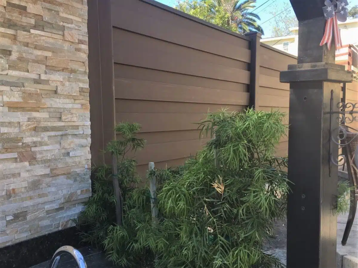 trex-contemporary-design-la-crescenta-ca A Trex fence with the Horizons horizontal system next to a textured rock wall.
