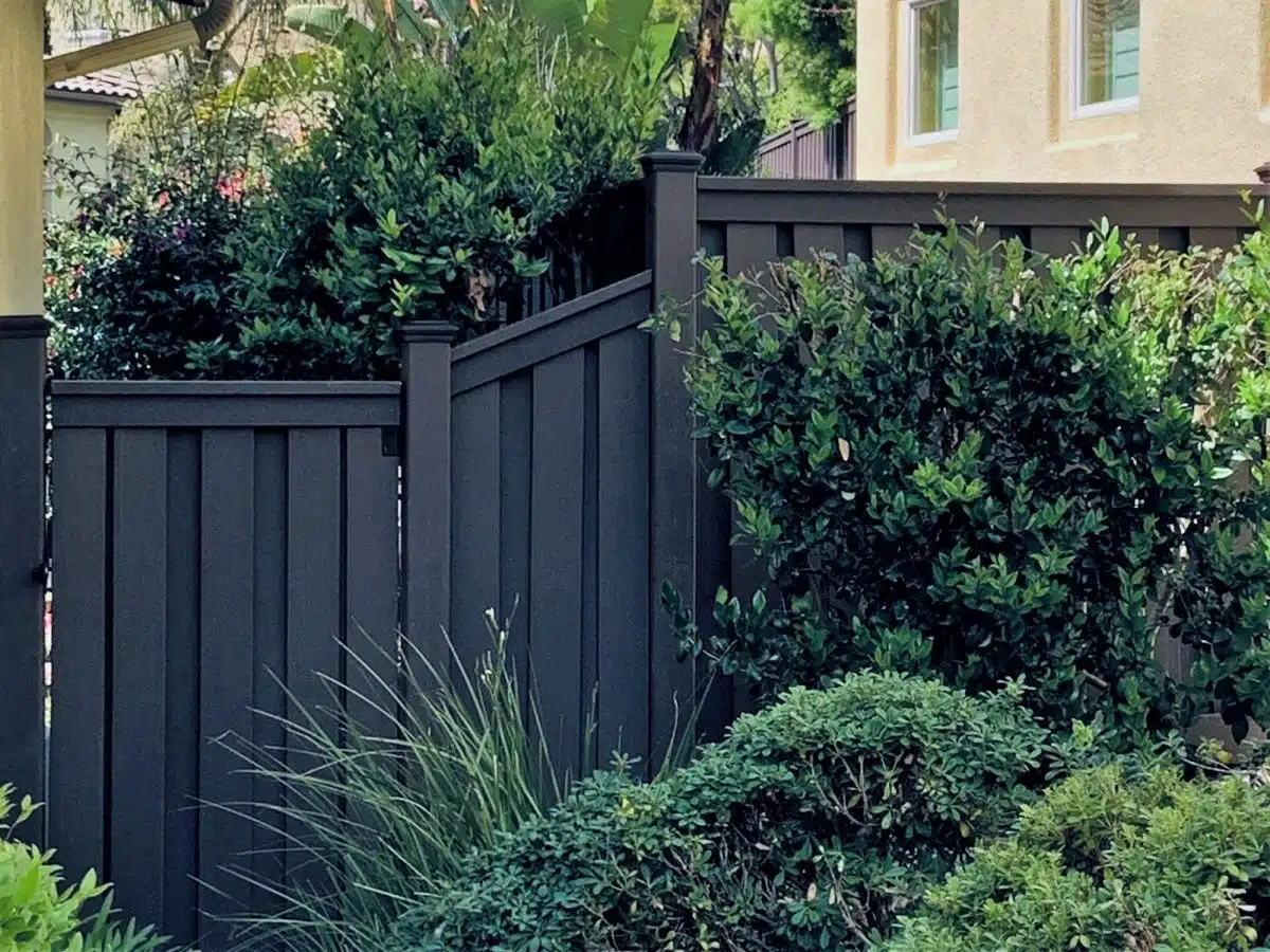 trex-fencing-gate-with-sloped-section-california A Trex gate with a sloped section next to it closing off a backyard.